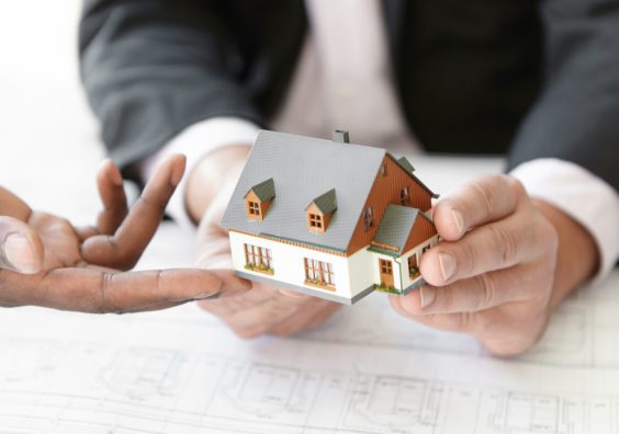 Architecture, building and construction concept. Cropped shot of two engineers evaluating design of new housing project. African architect making presentation of scale model house to his partner